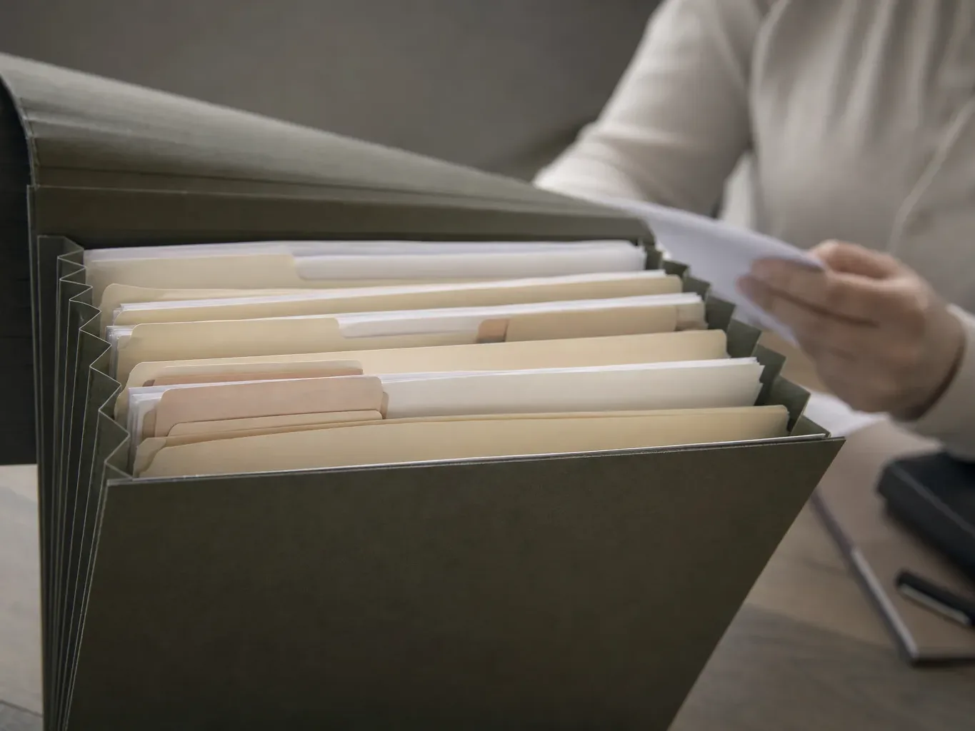 A close-up of a credit file folder open on a desk with tabs and documents inside